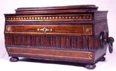 A tea chest incorporating both inlay and carved elements of decoration. The separate ornament and brass line are typical of early Regency. ad30.jpg (46688 bytes)