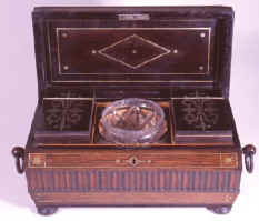 A tea chest incorporating both inlay and carved elements of decoration. The separate ornament and brass line are typical of early Regency. ad33.jpg (53835 bytes)