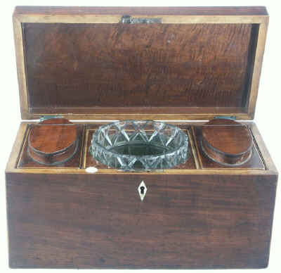 Hygra: Georgian mahogany three compartment tea chest having twin oval toped lift-out wooden canisters flanking a cut glass bowl. Circa 1790. 