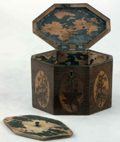 An Octagonal Caddy veneered in harewood and inlaid with oval marquetry panels depicting country flowers. Circa 1790