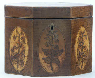 An Octagonal Caddy veneered in harewood and inlaid with oval marquetry panels depicting country flowers. Circa 1790