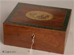 729JB: Rosewood veneered box with a hand coloured print of a classical figure and edged with a paper print of oak leaves. The box is in the neoclassical tradition of the late 18thearly 19th century, which drew its inspiration from ancient art. Ladies dressed in diaphanous classical robes and posing as figures of classical mythology, were  thought to be the height of fashion at the time, with women such as Emma Hamilton (Lord Nelsons mistress) sporting such affectations for after-dinner entertainment.
