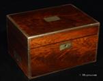 746JB:Box veneered in well figured mahogany with brass edgings and flat-folding handles. It has an unusual interior arrangement and a side drawer. Inside the lid there is an envelope Circa 1850 
