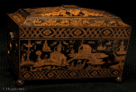 TC146: An immportant penwork tea chest, true to the spirit of the Regency. Its shape is of pure Egyptian inspiration. The top is decorated in designs of neoclassical derivation. The center features a pattera pattern slightly suggestive of a flower. The lower surround and the wide triangular panels feature acanthus leaves. The narrower sides have leaves enclosing either a stylized pinecone (ancient symbol of fertility) or a pineapple (a fruit of the East). The main body of work is in chinoiserie. The figures and landscapes have a light element, which was introduce
 