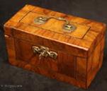 TC538:  18th century tea caddy veneered in figured walnut and having a brass carrying handle and escutcheon. Inside he caddy has one compartment which is lined with lead foil. However there is evidence that the caddy had three compartments previously. Circa 1770. 
