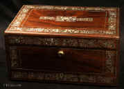 JB 514: Antique figured rosewood box with rounded edges, inlaid to the top and front with fine inlays of mother of pearl and white metal depicting stylized curved foliage, the box having a liftout tray, a separately locked lidded drawer fitted for jewelry, and in the lid a document wallet with gold tooling and velvet. The box is labeled by Thomas Woolfield, Manufacturer, No. 71 & 72, CHURCH STREET LIVERPOOL. Inside the box retains its original embossed leather silk and velvet linings. New detachable velvet pads have been made for the compartmentalized lift out tray. Circa 1835  Enlarge Picture