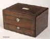 JB313: A figured rosewood veneered box with rounded edges, white metal (pewter) and mother of pearl accents having two liftout trays fitted for jewelry. Inside the lid is lined with ruched satin framed with gold embossed leather and opens down to  a document wallet. The lower drawer which is separately locked using the same key as the box,  is a writing box with Tyrian purple writing surface compartments for writing implements and paper. Circa 1845. Enlarge Picture