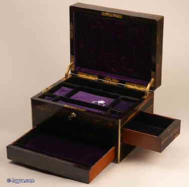 JB312: Antique box veneered in strongly figured  coromandel, on a mahogany construction with rounded brass edging to all sides,  and  working Bramah lock with key. The box is high quality, which continues into the interior. It is lined in velvet, and embossed leather. It has two  sprung drawers which are  fitted for jewelry released by pressing buttons,  Circa 1840. Enlarge Picture