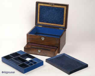 JB313: A figured rosewood veneered box with rounded edges, white metal (pewter) and mother of pearl accents having two liftout trays fitted for jewelry. Inside the lid is lined with ruched satin framed with gold embossed leather and opens down to  a document wallet. The lower drawer which is separately locked using the same key as the box,  is a writing box with Tyrian purple writing surface compartments for writing implements and paper. Circa 1845. Enlarge Picture