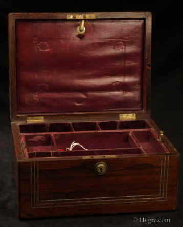 JB512: A figured rosewood box of oblong form having inlays of white metal and mother of pearl inlay depicting two birds drinking from a cup. The box also has  a Bramah lock, a side drawer fitted for jewelry  and a liftout tray. Circa 1830. Enlarge Picture