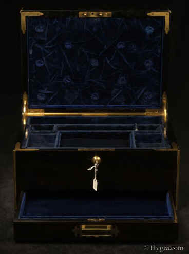 JB555: A particularly large brass edged  top quality box veneered with almost black coromandel (ebony)  and having inset brass carrying handles  Bramah lock  which also secures the drawer. The box retains its original velvet lined liftout tray.There is a silk lined tooled leather document wallet in the lid as well as a framed mirror and a space for another mirror. The box is lined with its original leather and velvet. Circa 1850. Enlarge Picture