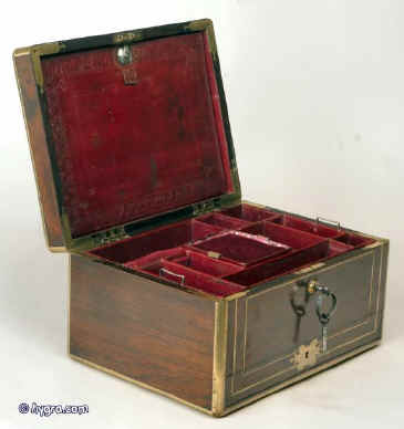 JB214: Antique top quality rosewood box edged and inlaid with brass, the top having an elaborate cartouche engraved with a armorial crest of a wingless Sphinx with a rose dexter,   the box having a leather covered liftout tray, working Bramah lock with key, and separately locked drawer fitted for jewelry, and embossed leather document wallet in the lid. Circa 1820. Enlarge Picture