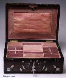 SB122: A rosewood veneered box, inlaid with mother of pearl and white metal in  a stylized pattern, which forms a fine foliated design in reverse having a lift out tray, still covered with its original printed pink paper  with divisions  for sewing.The workmanship is of high standard; for example, the box is edged with a rounded piece of wood which finishes it elegantly and also protects it.Circa 1835 Enlarge Picture