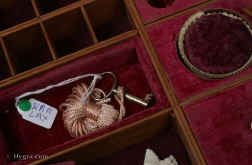 SB455: Rosewood and brass inlaid box in high Regency style circa 1815.  A box veneered in beautifully figured rosewood and inlaid with brass. The design of the inlay is of highly stylized flora, suggesting neoclassical designs hinting at palmette and (on the top) acanthus motifs. The juxtaposition of dark wood with bold brass inlay was popular in the early part of the 19th century. The wood and the bright brass were mutually enhancing. The Prince Regent (later George IV) commissioned such work for his Royal palaces. This technique, which perfected control of cutting and inlaying, required time and skill and it was very expensive at the time. It is no wonder that such work was popular at a time when excess was rife and style was given supreme social importance. The tray is beautifully made in yew wood. This is most unusual. The velvet covers are original. There are two early 19th century pin cushions which fit snugly in purposely cut-out circles. These pincushions are encased in turned and carved bone baskets. Such work is known as Dieppe work as it was mostly made by French refugees. Unfortunately the fragility of the baskets has caused them to suffer some damage, but they are quite lovely all the same. Working lock and key.
               Enlarge Picture