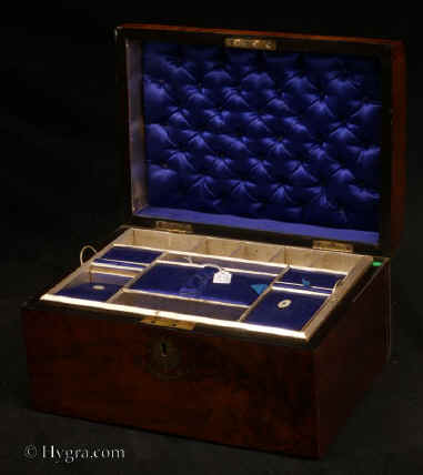 SB481: Burr walnut veneered box of rounded form, circa 1870. A box veneered in particularly well figured burr walnut. It is sparsely decorated with brass . The liftout  tray,  is all original and in particularly good condition; the  ruched back is also original.  Working lock and key. Enlarge Picture