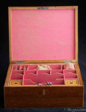 SB 493: A rare Georgian sewing box of rectangular form  edged with maple the top having a hand colored print depicting cherubs and framed with mitered purfling having a lift-out tray still retaining turned Tunbridge ware whitewood sewing tools. Circa 1800. Enlarge Picture