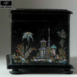 A serpentine fronted two compartment papier mch tea caddy decorated with chinoiserie painting on an iridescent pearl shell inlay. Enlarge Picture
