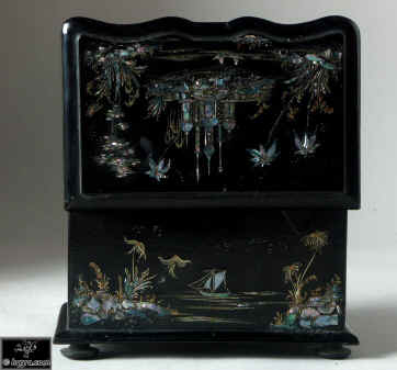 A serpentine fronted two compartment papier mch tea caddy decorated with chinoiserie painting on an iridescent pearl shell inlay. Enlarge Picture