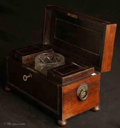 TC491: Rosewood,  tea chest inlaid with brass tea chest having embossed gilt brass drop ring handles to the sides made by William Dobson. Inside there are three compartments containing two hinged lift out tea canisters and a central well with original deeply cut crystal sugar bowl. Circa 1810. Enlarge Picture