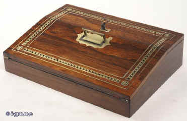 WB151: A rosewood writing slope of  with fine brass and ebony inlay. The upper flap covers compartments for pens and inkwells. The lower flap opens down to a velvet (replacement) covered writing surface framed with a cross-banding of rosewood. the box retains an original inkwell. There is a compartment for holding paper under the writing surface. 1820 Enlarge Picture
