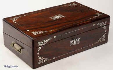 WB165:  Antique figured rosewood writing box with rounded edges, and countersunk brass carrying handles, inlaid to the top and front with fine inlays of mother of pearl and white metal (pewter) depicting stylized curved foliage, opening to an embossed velvet  writing surface and compartments for writing implements and paper. The box also has an unusual sprung secret drawer  hidden under the pen-tray. Circa 1840. Enlarge Picture