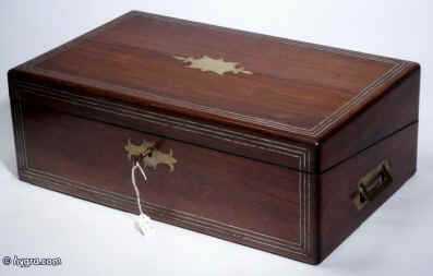 WB168 Antique figured rosewood writing box with rounded edges, and countersunk brass carrying handles, name plate and escutcheon , inlaid to the top and front with  inlays of white metal, opening to an embossed leather writing surface and compartments for writing implements and paper. The box also has secret drawers hidden behind a sliding panel. Circa 1840. Enlarge Picture