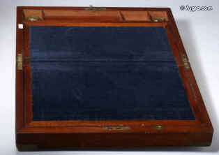 WB171: Flame mahogany writing box with brass shield shape name plate, and escutcheon, brass corners and straps opening to a fitted interior with velvet covered writing slope, compartments for writing tools and inkwells. Under the writing surface there are places for storing papers. There are also secret drawers concealed behind a sprung panel released by pulling on one of the divisions. Circa 1845. Enlarge Picture
