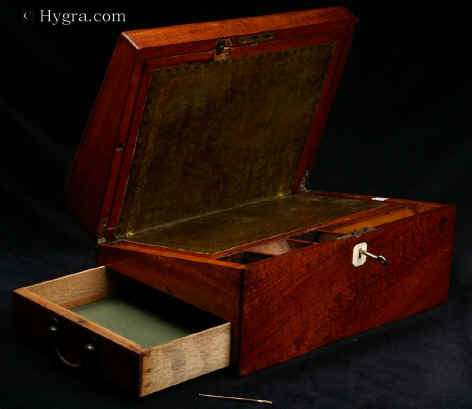WB472: Solid mahogany writing box of dovetail construction in typical late 18th century style c1790. This is a solid mahogany writing box made in the characteristic late 18th century style, designed to withstand military campaigns and/or extensive travelling. Inside there is a sloping leather writing surface (modern replacement). There are further compartments for papers and writing implements. The box also has a side drawer.    Enlarge Picture