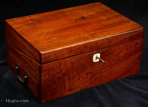 WB472: Solid mahogany writing box of dovetail construction in typical late 18th century style c1790. This is a solid mahogany writing box made in the characteristic late 18th century style, designed to withstand military campaigns and/or extensive travelling. Inside there is a sloping leather writing surface (modern replacement). There are further compartments for papers and writing implements. The box also has a side drawer. Enlarge Picture