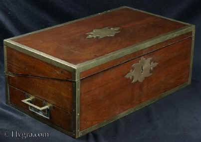  WB482: High quality  Regency brass edged mahogany writing box in the military style, with countersunk brass handles opening to embossed leather (replacement) writing surface and compartments for pens and inkwells, having compartments for paper under the flaps. The box also features a mechanism so that it can be used as a reading stand or lectern. There are three secret drawers concealed behind a sprung panel. The box retains two original inkwells with screw tops.  Circa 1810.Enlarge Picture