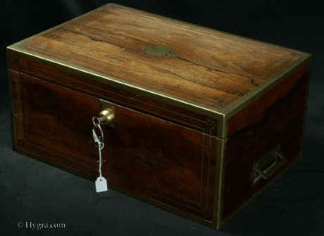  WB483: Regency brass edged  figured rosewood  writing box with brass accents, countersunk brass handles opening to an embossed leather writing surface (replacement) and compartments for pens and inkwells, having compartments for paper under the flaps. There  are secret drawers under the pen compartment concealed behind a sprung flap released by pulling up the wall  of the right inkwell compartment.  The box has two locks. The main one is Bramah and slightly later than the box.  one of the flaps also has a  lock. There is a side drawer for more papers. Circa 1820 Enlarge  picture