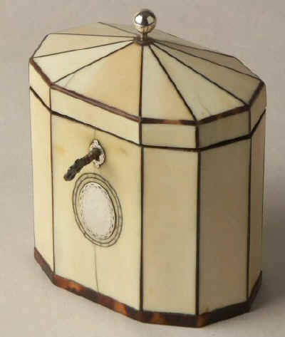 Hygra: A ten sided tortoiseshell strung ivory  tea caddy with a pyramid top  having a silver ball finial,   a silver escutcheon, and silver plaque on the front encircled with pique point. Circa 1790.