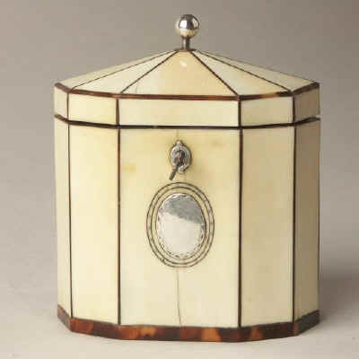 Hygra: A ten sided tortoiseshell strung ivory  tea caddy with a pyramid top  having a silver ball finial,   a silver escutcheon, and silver plaque on the front encircled with pique point. Circa 1790.