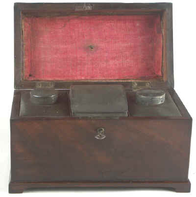 A flame mahogany tea chest of traditional Chippendale form with cavetto molding to the top and edged subtly with rope twist banding having brass edge escutcheon and Dutch drop handle and containing three tinned ferrous metal lift out containers. Circa 1775. mahchcan02.jpg (35202 bytes)