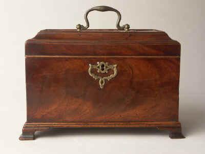 A flame mahogany tea chest of traditional Chippendale form having fretted brass escutcheon and top carrying handle with a sliding side revealing a secret spoon drawer and standing on bracket feet. Circa 1770