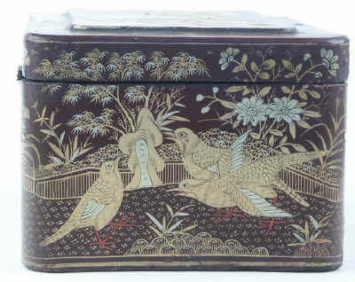 A Chinese export lacquer tea caddy in reddish earth colored lacquer having rounded corners decorated with two colors of gold depicting groups of birds highlighted in red lacquer. Circa 1840