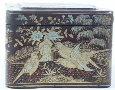 A Chinese export lacquer tea caddy in reddish earth colored lacquer having rounded corners decorated with two colors of gold depicting groups of birds highlighted in red lacquer. Circa 1840