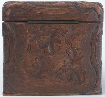 A tea caddy of cube form with the top and sides deeply carved depicting trailing oak leaves