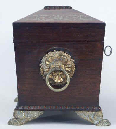 A Rosewood three compartment  brass Inlaid Tea Chest with gadrooned framings having twin lift-out  wooden canisters flanking a cut crystal bowl standing on embossed gilded brass feet and with drop handles, Circa 1825.