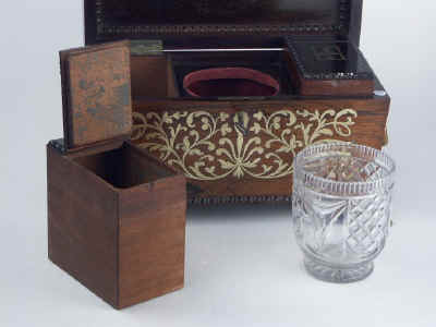 A Rosewood three compartment  brass Inlaid Tea Chest with gadrooned framings having twin lift-out  wooden canisters flanking a cut crystal bowl standing on embossed gilded brass feet and with drop handles, Circa 1825.