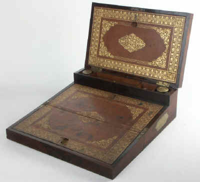 A very fine brass bound triple opening writing box with secret drawers, made by one of the most eminent  makers of the Regency period. The box is marked 'Bayley's' 17. Cockspur St. ' follow Link. Rosewood crossbanded with ebony inlaid with separate brass elements having 'lucky' quatrefoil centers. The quality screams.