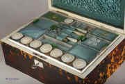 SB121: A rare fully fitted tortoiseshell sewing box of rectangular form and shaped top by Thos' Lund of Cornhill, having ivory facings, silvered hinges and lock, mother of pearl escutcheon and name plate engraved "Mrs. Brown". Inside there is a liftout tray with green and blue silk coverings  and supplementary lids  containing  turned and carved mother of pearl spools (8) and other sewing tools. The inside the lid is covered in ruched blue silk framed with a smooth silk border and contains  a document wallet in the lid. Circa 1820. Enlarge Picture