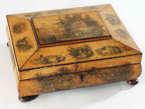  A shaped Scottish sewing box made from sycamore decorated with transfer decoration of different views. 
The views are romantic visions of the countryside. The interior is partitioned for sewing tools with a lidded central compartment decorated with yet another picture. Second quarter 19th century.  
