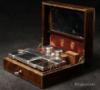  JB601: Fine brass bound  rosewood  NCESSAIRE DE VOYAGE by L. Aucoc Ain, Paris, with small Bramah type lock, the tightly packed compartmentalized interior lined with earth red shagreen leather and velvet and having silver topped cut crystal bottles and boxes. Circa 1840. 