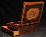 An early 19th century partridgewood writing box with inlaid banding and decorated with a hand coloured engraving depicting a winged Victory ahead of a Classical laurelled hero riding in his chariot. The box has side carrying handles a drawer, inner velvet writing surface and places for writing materials and accessories. Circa 1800.