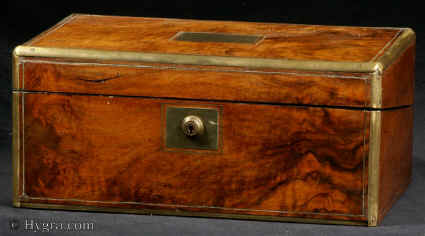 Writing box veneered in figured walnut circa 1880:  Writing box veneered in figured walnut, with rounded brass surround and brass lines. Strong Bramah lock. Inside the box is veneered in ebonised wood. The writing surface is lined in the original blue gold-embossed leather. The inkwells are added (new). The flap lifts to a mahogany interior. There are two secret drawers. Working lock and key.<br>
              Enlarge Picture