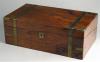 A brass bound walnut veneered writing box  opening to an embossed  leather writing surface and compartments for writing implements and paper. 