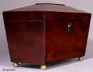 TC121: A flame mahogany tea caddy of tapered pyramid shape standing on brass ball feet with two lidded compartments and a central place for sugar bowl circa 1820. Enlarge Picture